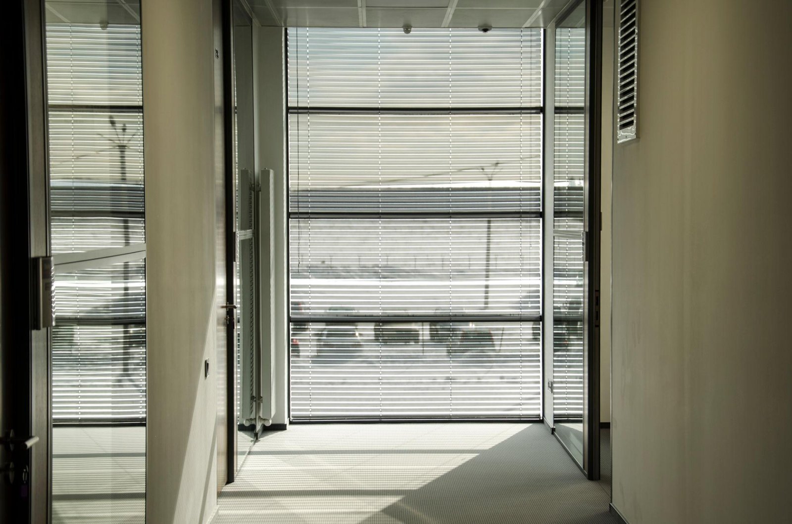 Modern office space with horizontal blinds providing light control and privacy, creating a comfortable and well-lit environment.