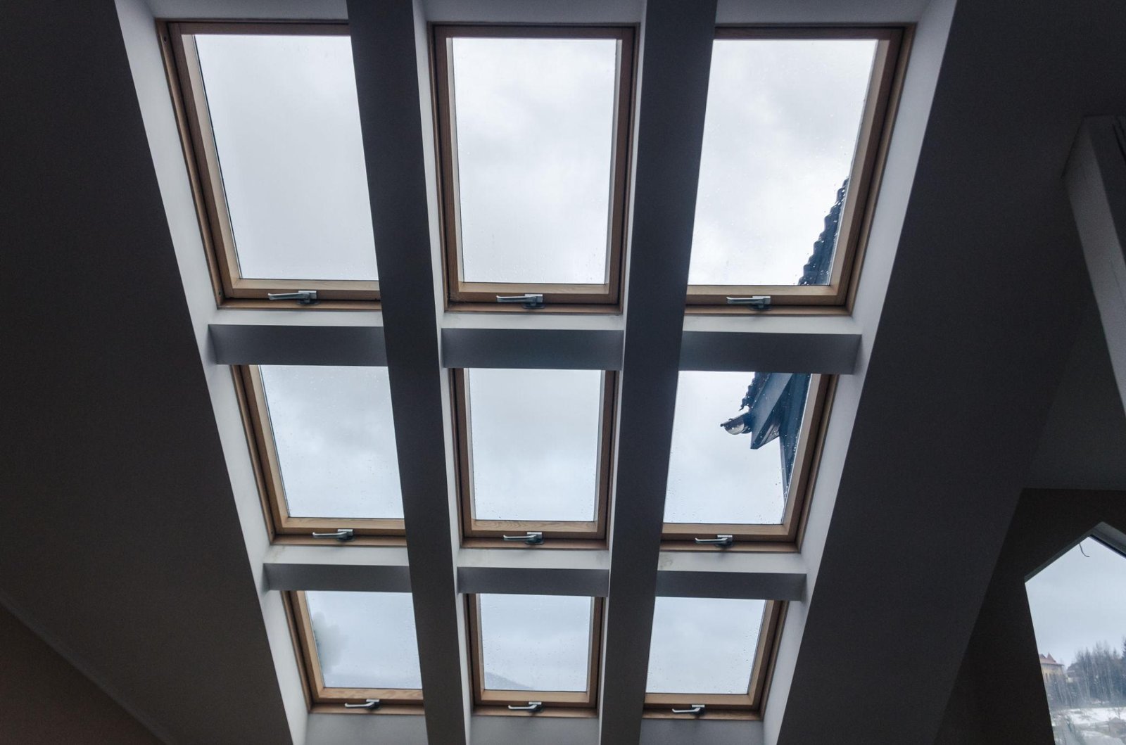 View of skylight windows in a modern room, showcasing advanced light control with multiple roof windows for ample natural light.