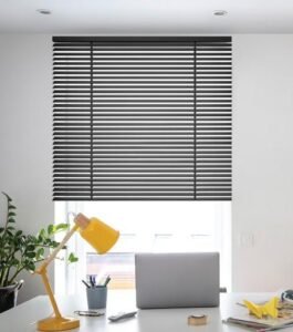 Black horizontal blinds providing light control and privacy in a modern workspace, showcasing timeless elegance and functionality.