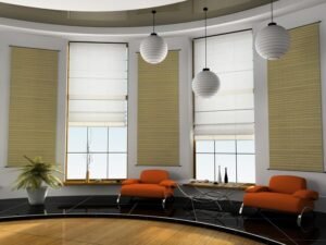 Modern living room with two orange chairs, black tiled flooring, and beige Roman blinds covering the windows. The space includes three pendant lights and a decorative plant on a table, with a minimalist design and large windows letting in natural light.
